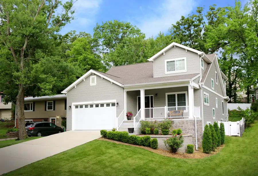 A new home build in Kirkwood, MO by Agape Construction featuring custom landscaping against a sloped yard.