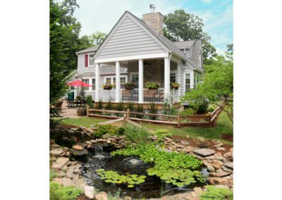 inviting scenic outdoor back porch addition flowers trees garden landscaping stonework pond