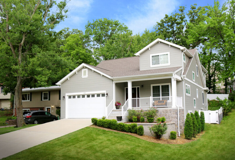 A new home build by Agape Construction featuring custom landscaping against a sloped yard.