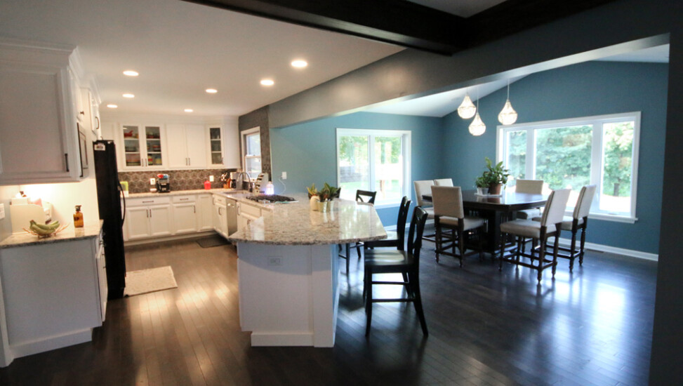 A home's kitchen dining area addition by Agape Construction, featuring ample natural light.