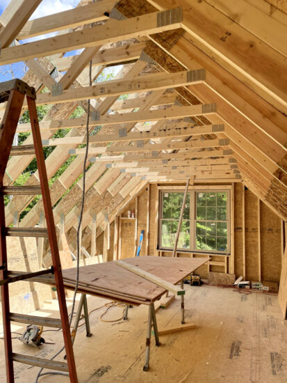 An in-progress view of a cabin's construction, seen by A-framing on the roof section.
