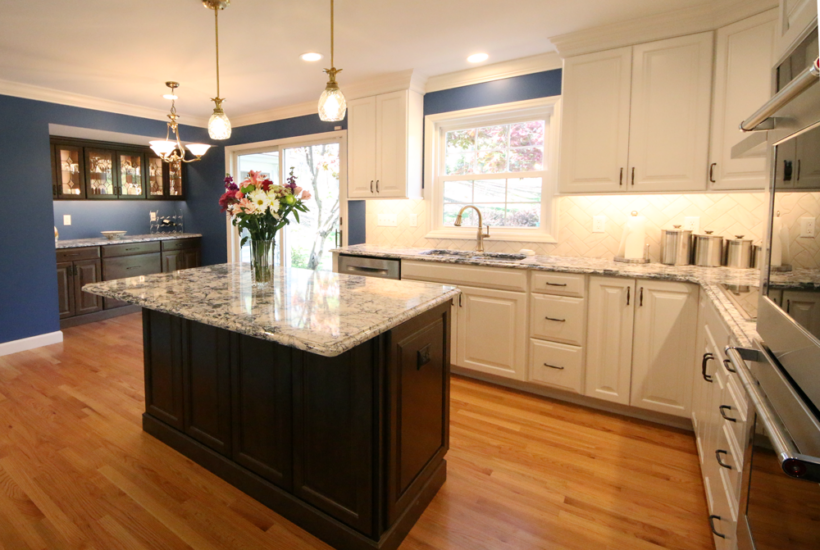 A home kitchen renovation, featuring contrasting cabinetry of deep browns and off-white by Agape Construction.