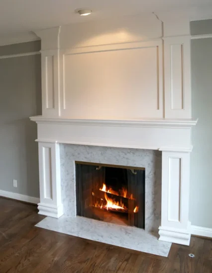 Custom, white marble fireplace with carpentry accents, by Agape Construction.