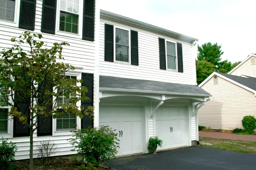 A second-story extension over two-door garage featuring grey accents. By Agape Construction.