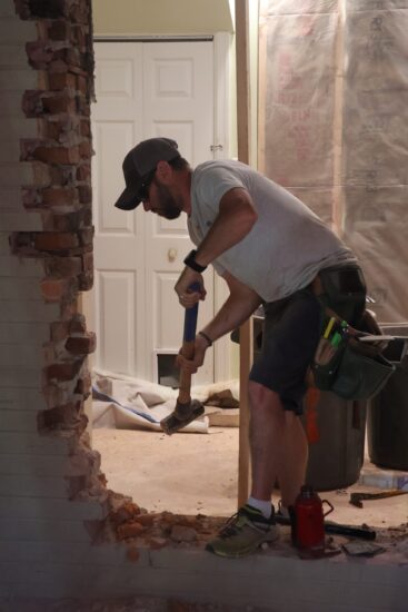 construction worker removing exterior wall