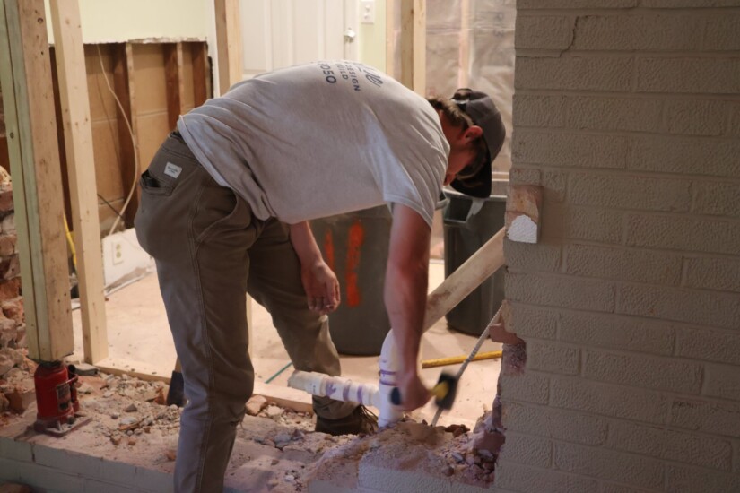 construction worker removing an exterior wall