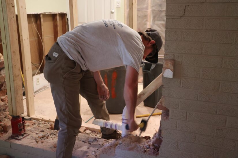 construction worker removing an exterior wall