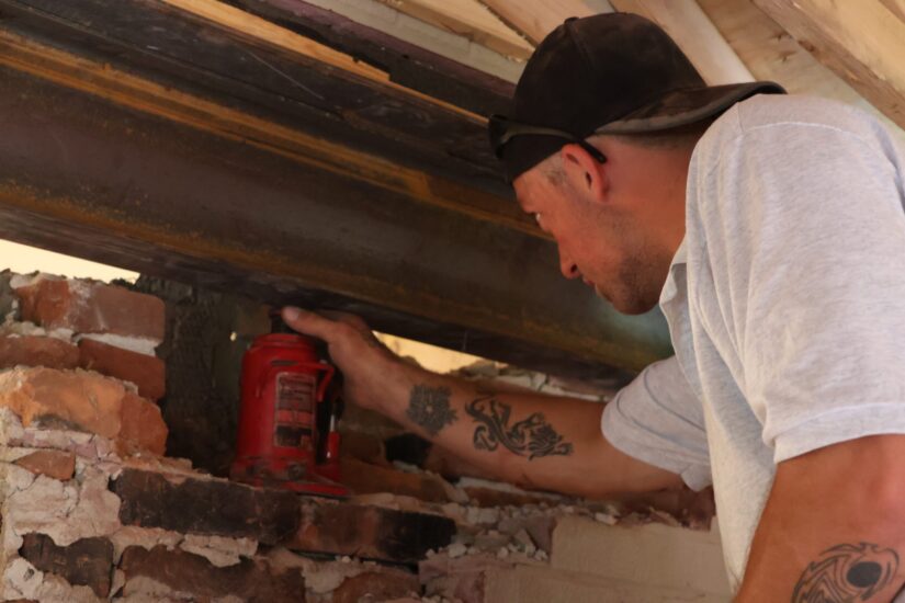 construction worker supporting home wall