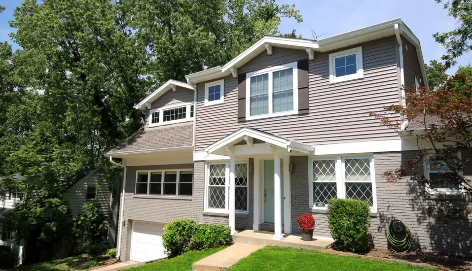 The exterior and facade of a split-level home with landscaping. By Agape Construction.