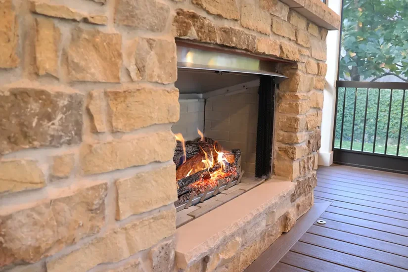 Outdoor fireplace with steel shielding and stone accents. By Agape Construction.