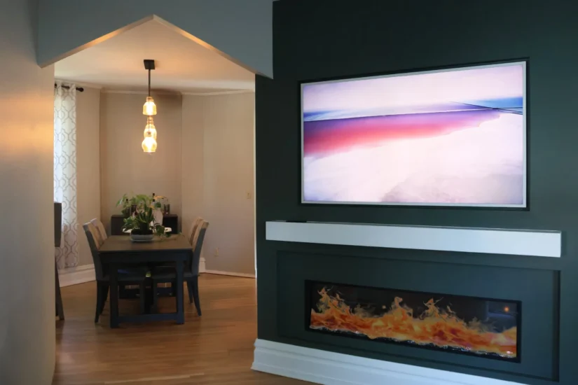 A modern accent wall with tv and fireplace, by Agape Construction.