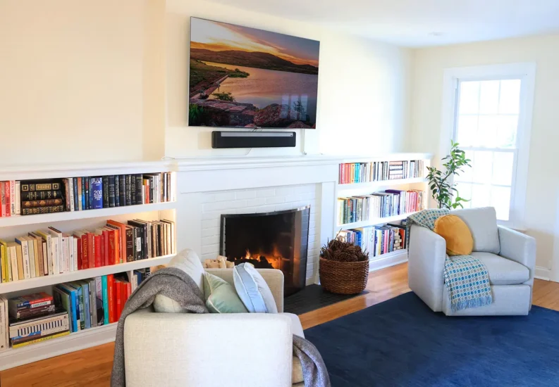 Living room fireplace with integrated bookshelves and wall-mounted tv. By Agape Construction.