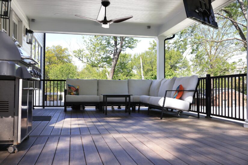 covered deck with ceiling fan and TV