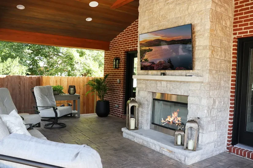 An outdoor pavilion space, including fireplace, tv, and seating. by Agape Construction.