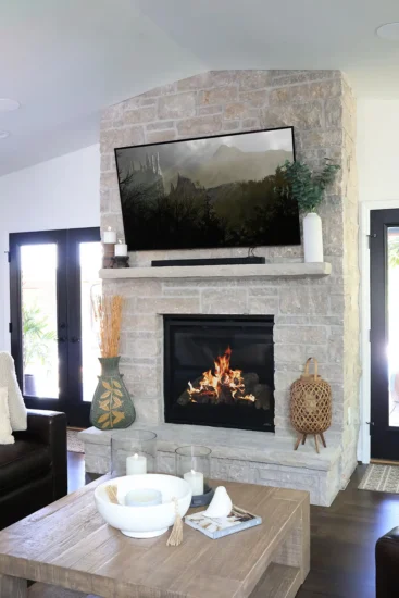 A double-fireplace with mounted tv, by Agape Construction.