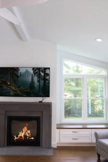 Fireplace addition by Agape Construction, within a bright, naturally-light sunroom.