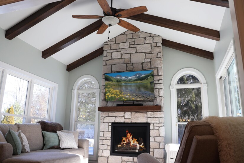 hearth room fireplace with floor to ceiling stone and exposed beams