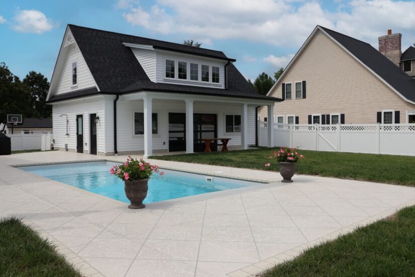 carriage house pool with stamped concrete surround