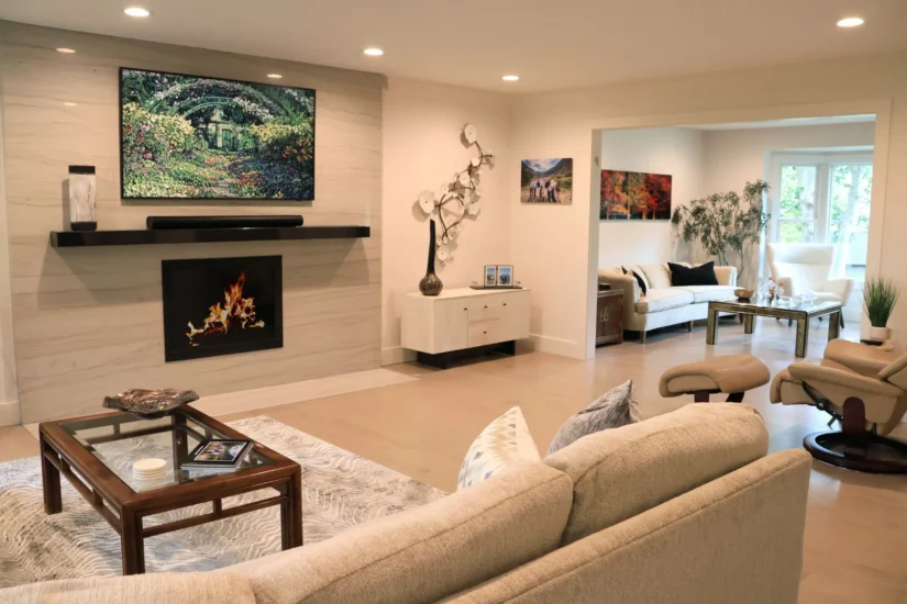 A fireplace, flush with quartz accent wall, under mounted tv, in a home living space. By Agape Construction.