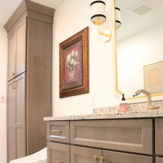 hall bath with neutral cabinetry and mixed metal finishes